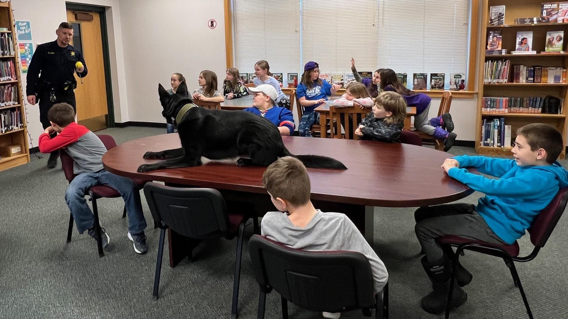 Officer Lent and K9 Knowlton demonstrate work to students in library